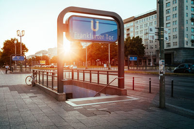 Subway sign at entrance by street in city