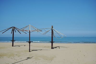 Lifeguard hut on beach against clear blue sky
