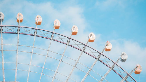 Low angle view of ferris wheel against blue sky