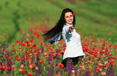 Smiling young woman standing on field