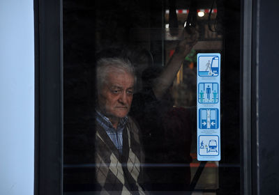 Thoughtful senior man looking through train window