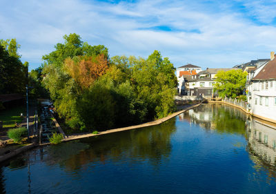 River amidst trees and buildings against sky