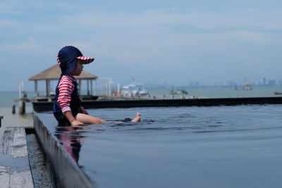 Man in sea against sky