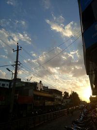 Road by city against sky during sunset