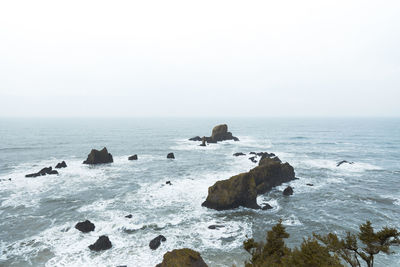 Aerial view of rock formation in sea against clear sky