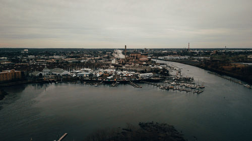 High angle view of townscape by river against sky