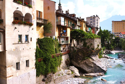 Canal amidst old buildings in town against sky