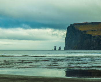 Silhouette people on beach against sky