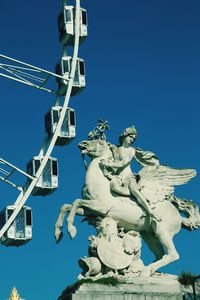 Low angle view of statue against blue sky