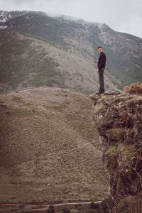 Full length of woman standing on mountain landscape