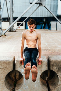 Full length of shirtless young man smoking