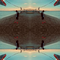 People on beach by sea against sky during sunset