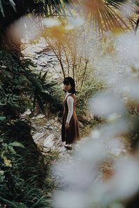 Full length of woman standing by tree