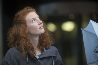 Young woman outside umbrella looking