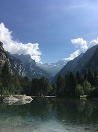 Scenic view of lake by mountains against sky