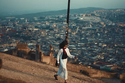 Woman standing in city against sky