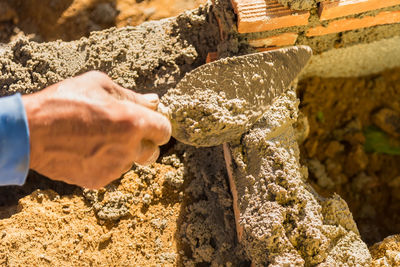 Close-up of worker hand holding with spatula at construction site