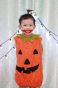 Portrait of smiling girl standing on wall during halloween