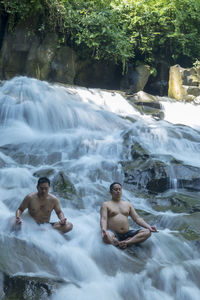 Full length of shirtless young man in water