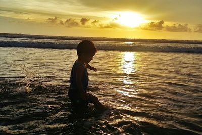 Boy on beach against sky