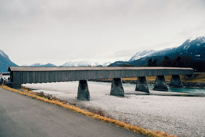 Road by mountains against sky