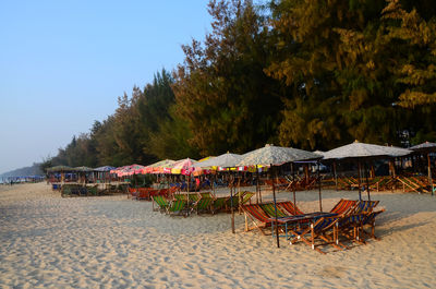 Chairs on beach against clear sky