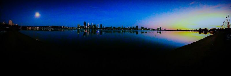 Illuminated cityscape against clear sky at dusk