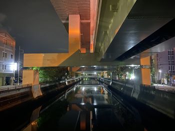 Illuminated modern buildings by canal at night