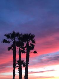 Low angle view of silhouette palm trees against romantic sky