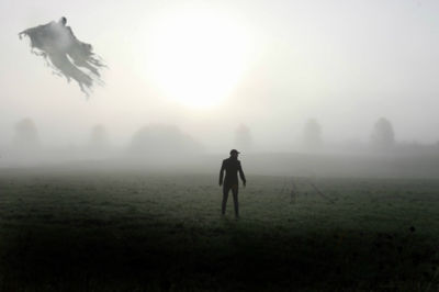 Man walking on field against sky