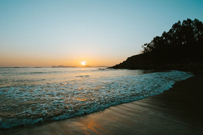 Scenic view of sea against clear sky during sunset