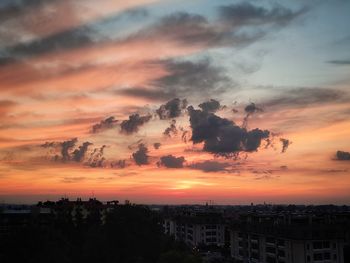 Silhouette buildings against sky during sunset