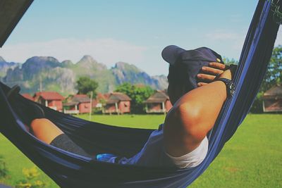 Young man relaxing on hammock at field