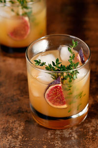 Bourbon sour cocktail with fig spices, lemon juice and syrup. garnish with figs and thyme.