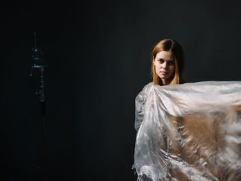 Portrait of woman against black background