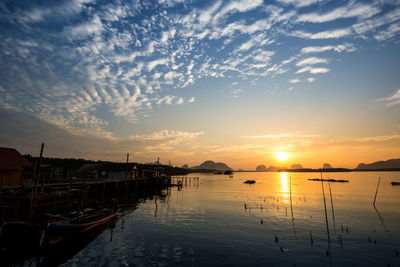 Boats moored in marina at sunset