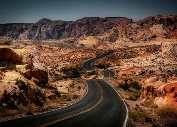 Road leading towards mountains against sky