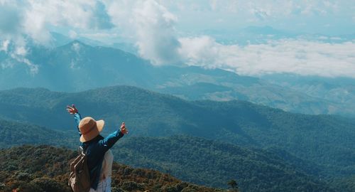 Woman with arms outstretched standing on mountain