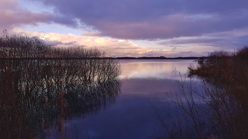 Scenic view of lake against sky at sunset