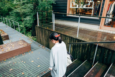 Rear view of woman standing by railing