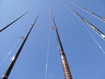 Low angle view of poles against clear sky