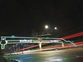 Illuminated bridge in city against sky at night