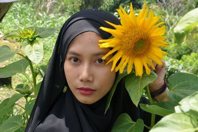 Portrait of woman with yellow flower