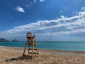 Lifeguard hut on beach against blue sky