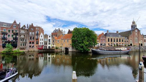 Canal amidst buildings against sky