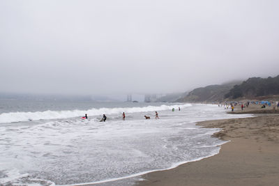 People on beach against sky