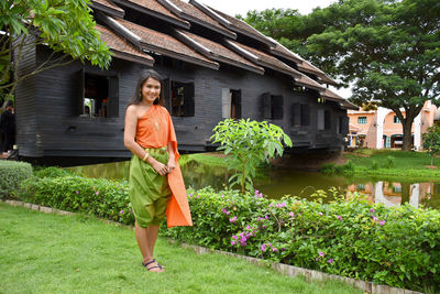 Portrait of smiling woman standing against plants