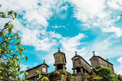 Low angle view of old chapels against cloudy sky