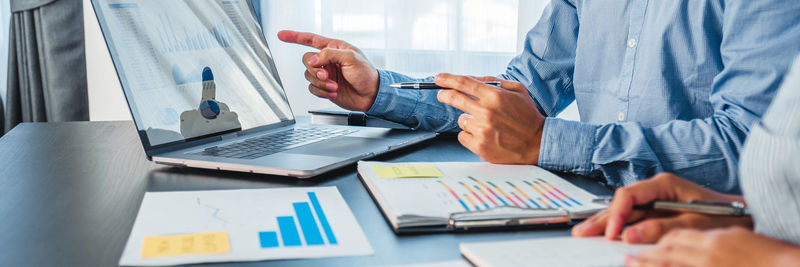 Midsection of business people working on table