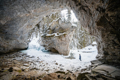 Person standing on rock in cave